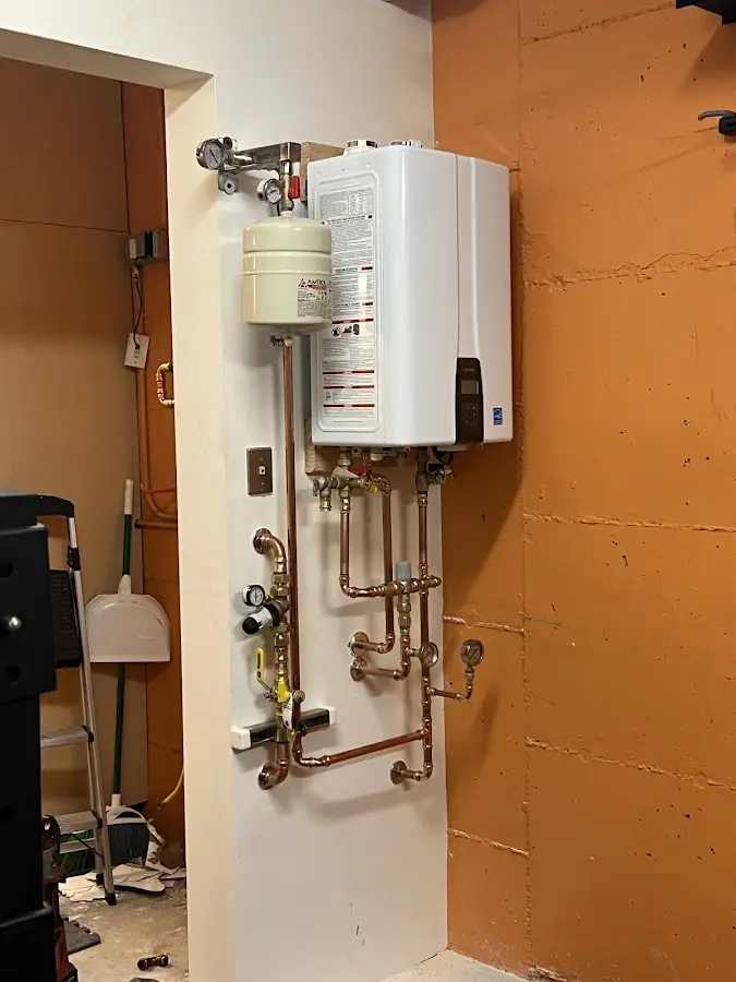 Plumbing technician inspecting water heater connections in South Elgin